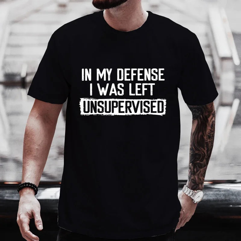 Person wearing a black t-shirt with text 'IN MY DEFENSE I WAS LEFT UNSUPERVISED' against a blurred background.