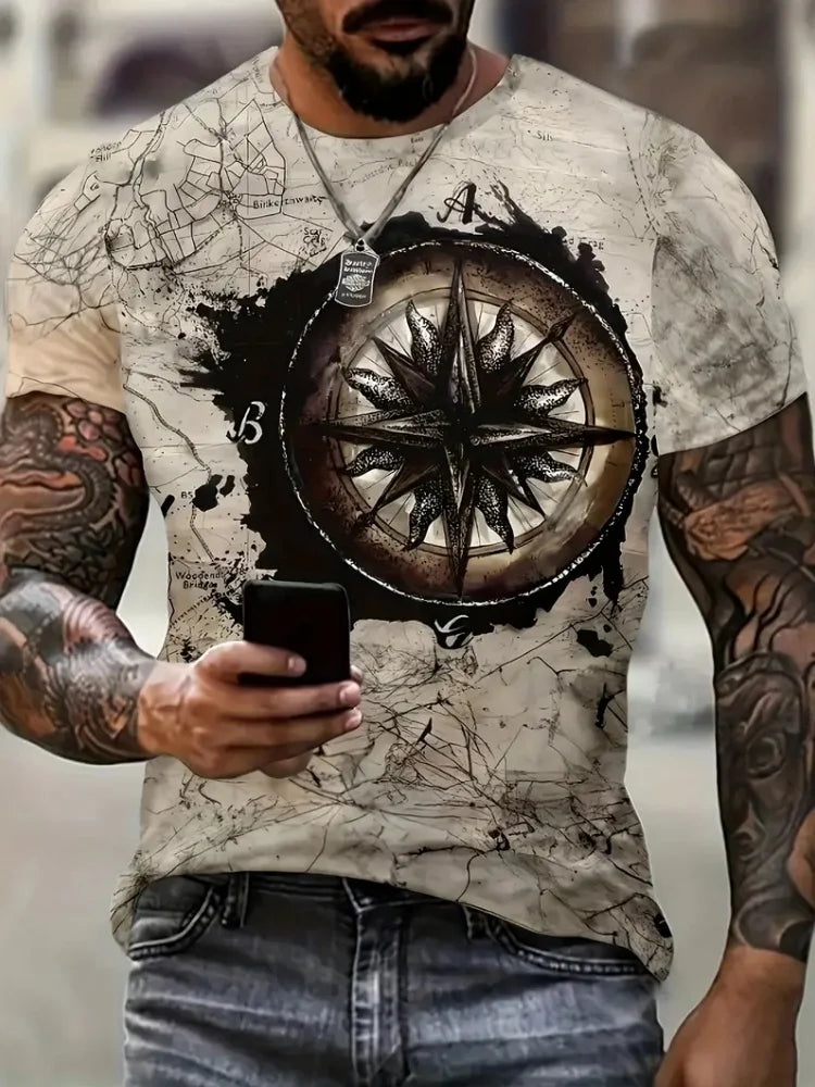 Person wearing a t-shirt with a compass design and tattoos holding a phone.