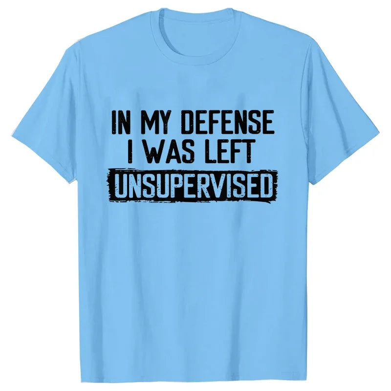 Light blue t-shirt with black text 'IN MY DEFENSE I WAS LEFT UNSUPERVISED' on a white background