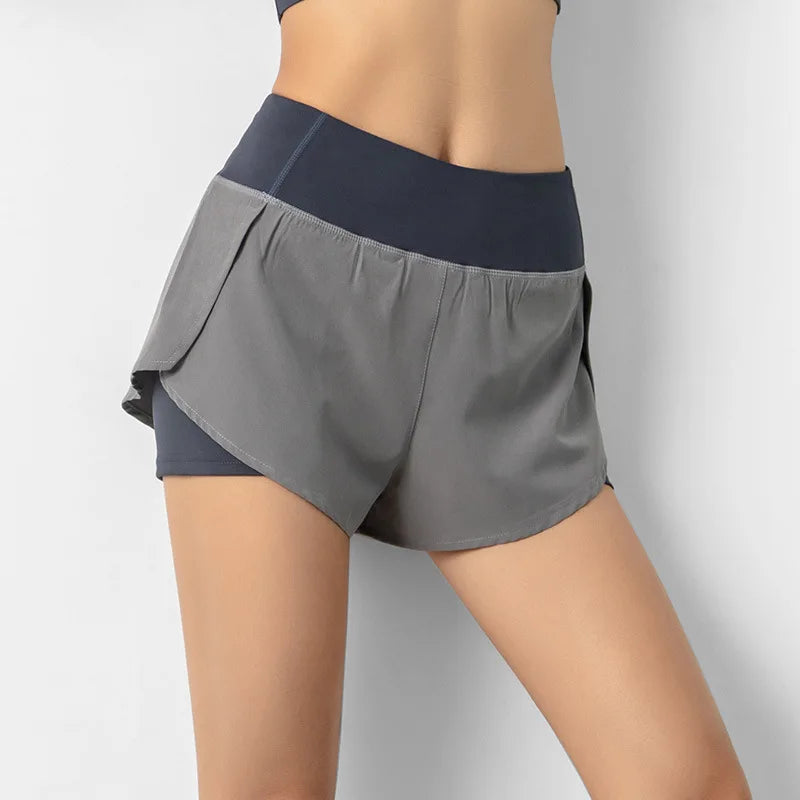 Gray athletic shorts with a navy waistband on a plain background