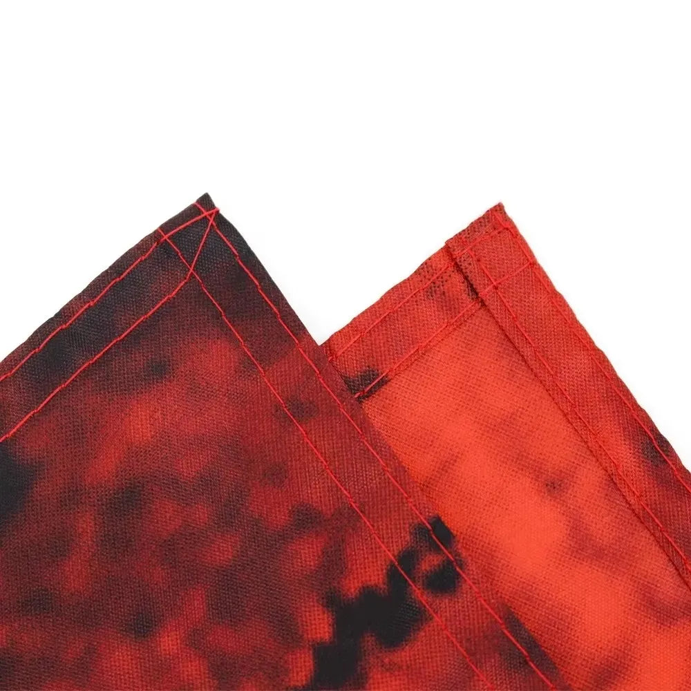 Close-up of red and black fabric with visible stitching on a white background