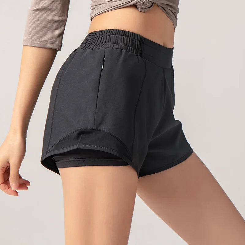 Black athletic shorts worn by a person on a plain background