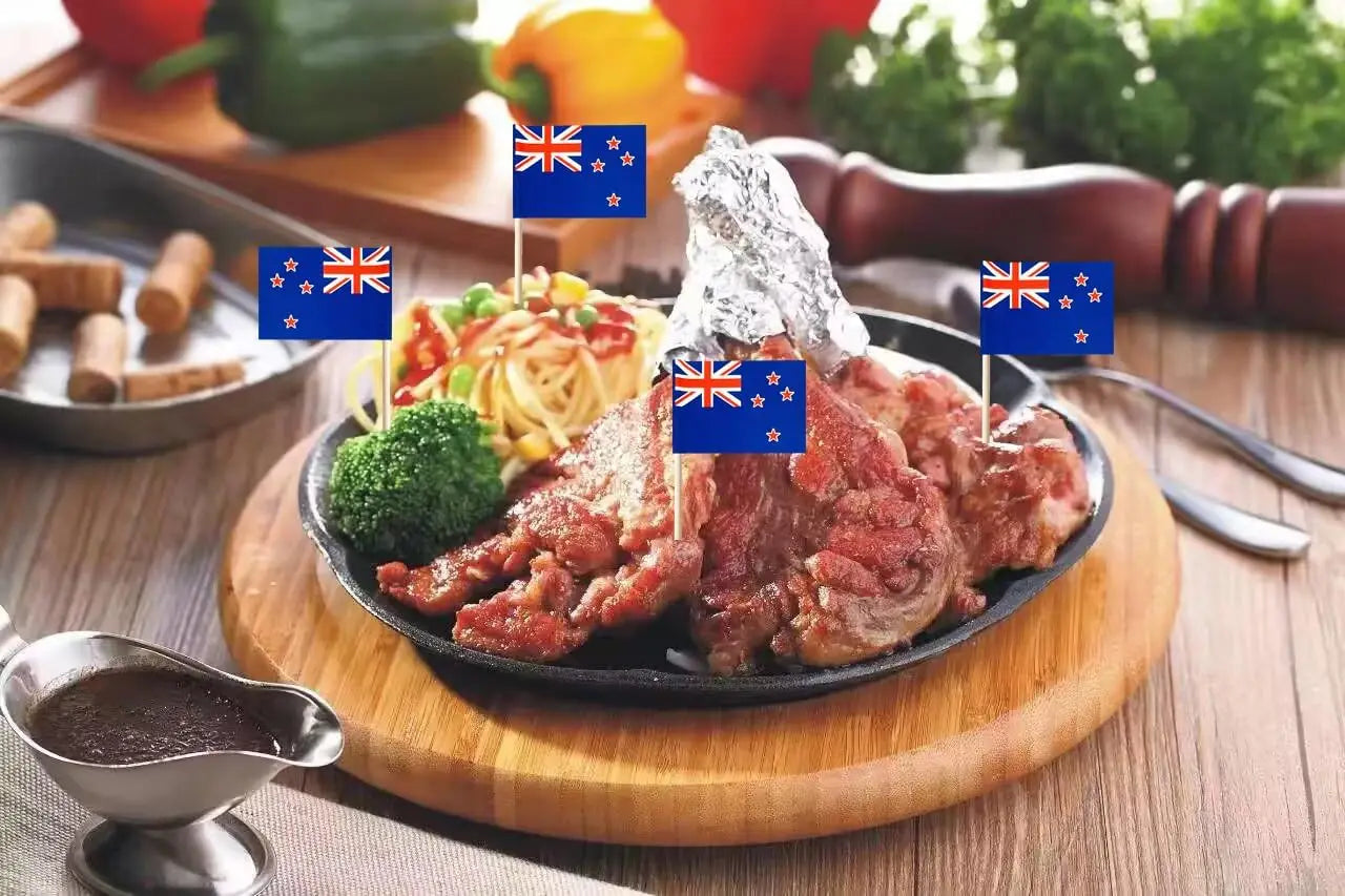 Plated meat dish with flags on a wooden table