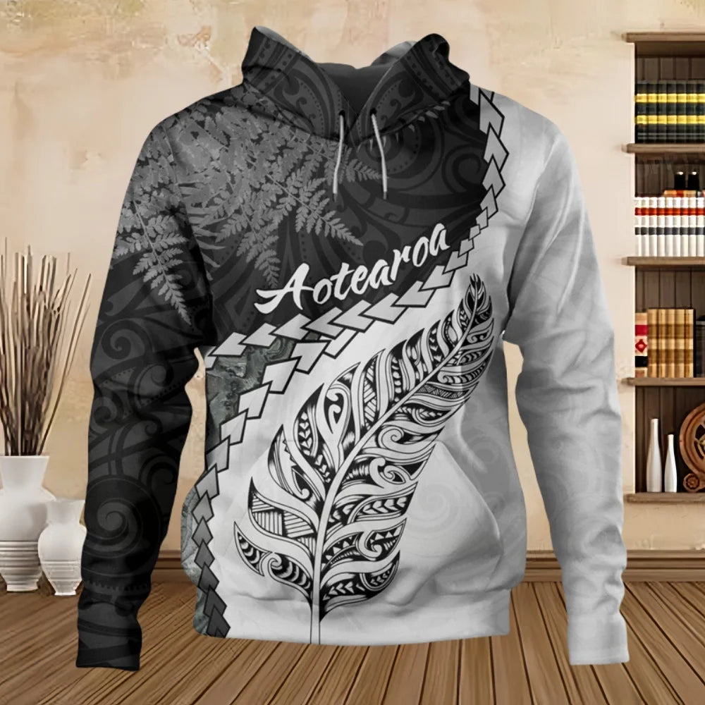 Hoodie with black and white design and 'Aotearoa' text on a wooden floor.