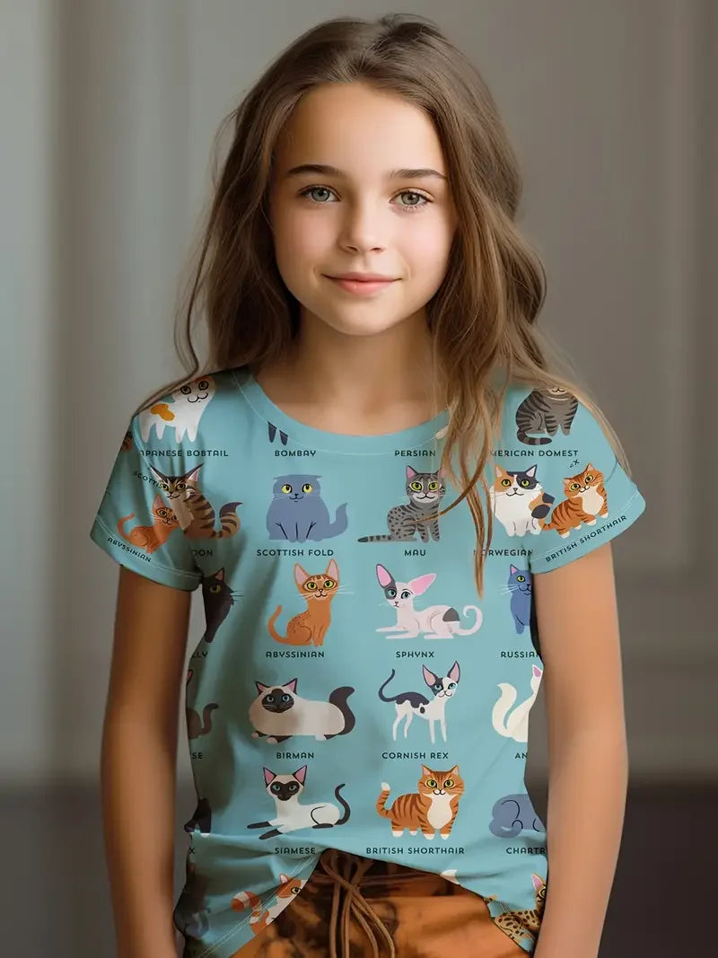Young girl wearing a blue t-shirt with cat illustrations and text