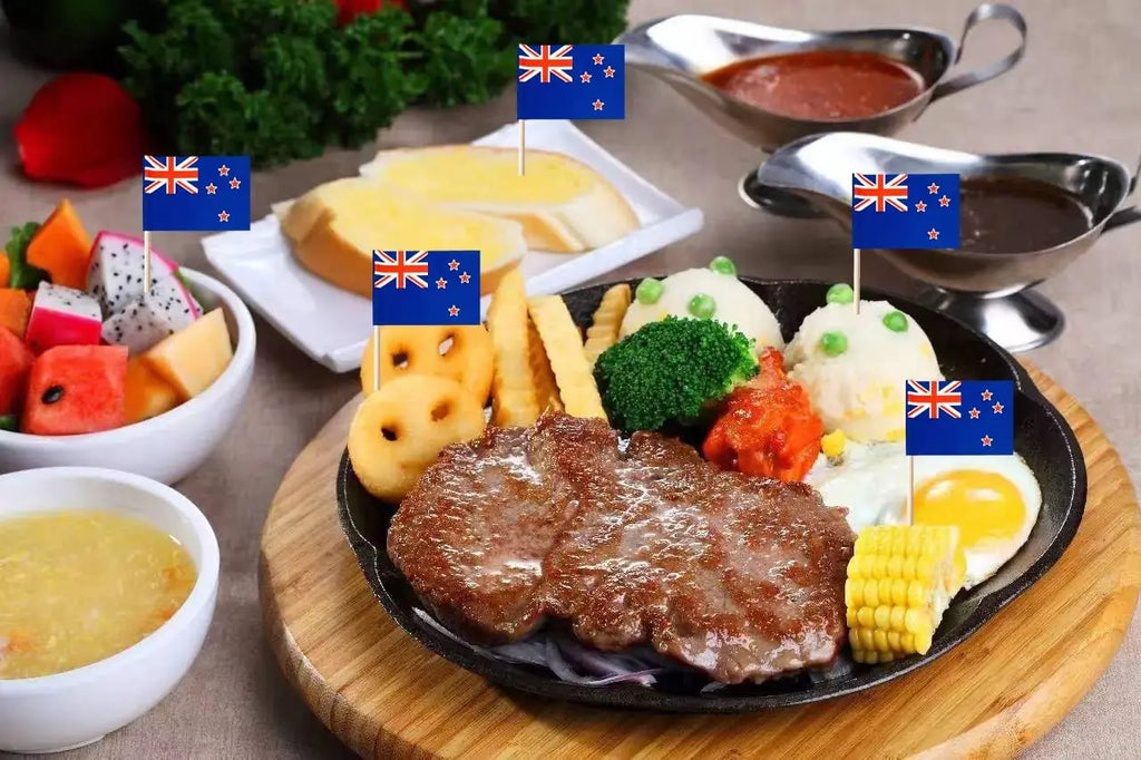 Plated meal with steak, vegetables, and sides on a wooden board, featuring New Zealand flags.