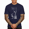 Navy blue t-shirt with a graphic of a bull on a toilet and text 'THIS IS' worn by a person.